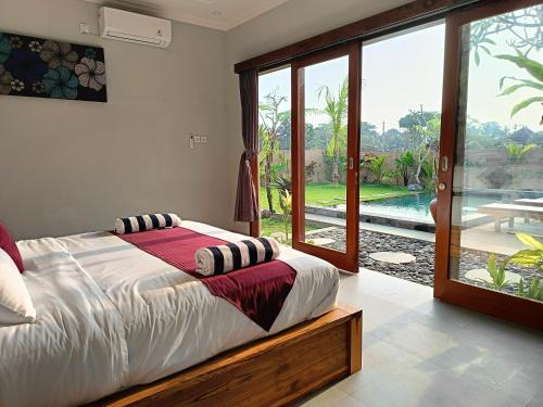 a bedroom with a bed and a large window at 2BR Ubud private pool kitchen in Ubud