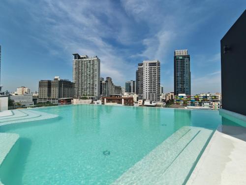 a swimming pool on top of a building with a city skyline at Wanda Jin Residences The Ease Sierra Bangkok in Bangkok