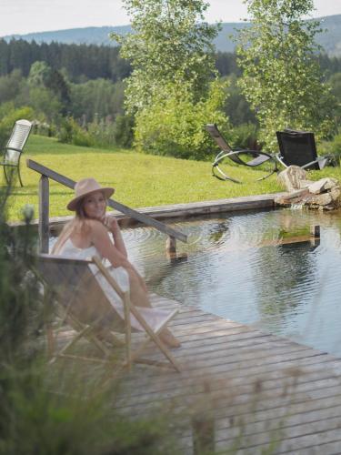 a young girl sitting in a chair in the water at Usedlost U lípy Blatiny in Sněžné