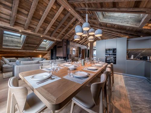 une salle à manger avec une grande table et des chaises en bois dans l'établissement Penthouse duplex de luxe avec services inclus - 5 chambres - FR-1-613-121, à Les Allues