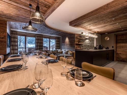 une salle à manger avec une longue table avec des verres à vin dans l'établissement Chalet luxueux avec sauna, home cinéma et bain norvégien - FR-1-613-127, à Les Allues