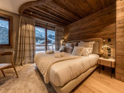 une chambre avec un grand lit avec un mur en bois dans l'établissement Chalet luxueux avec sauna, home cinéma et bain norvégien - FR-1-613-127, à Les Allues