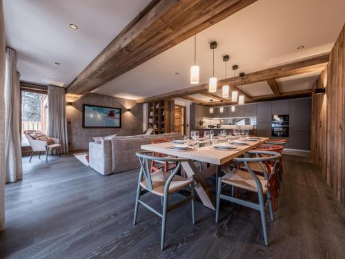 une salle à manger et une cuisine avec une grande table et des chaises dans l'établissement Appartement de luxe avec conciergerie 5*, vue montagne, 3 chambres, ski room - FR-1-613-125, à Les Allues