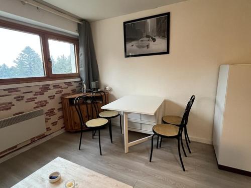 Cette chambre dispose d'une table, de chaises et d'un réfrigérateur. dans l'établissement Studio 3 personnes en station avec parking couvert - FR-1-787-115, à Laveissière