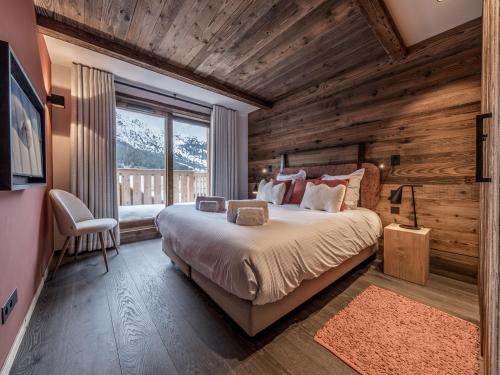 une chambre avec un lit dans une pièce aux murs en bois dans l'établissement Appartement de luxe avec conciergerie 5*, vue montagne, 3 chambres, ski room - FR-1-613-125, à Les Allues