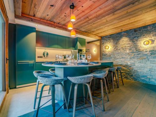 un bar dans un restaurant avec des murs verts et des tabourets dans l'établissement Appartement de luxe avec jacuzzi et terrasse panoramique à Méribel - FR-1-613-134, à Les Allues
