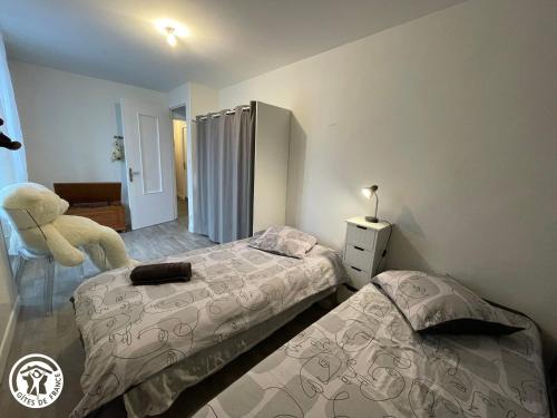 - une chambre avec 2 lits et une chaise dans l'établissement Gîte Zen et Confort au cœur du Sud Vendée, proche Parc Natural du Marais Poitevin - FR-1-426-571, à Saint-Hilaire-des-Loges