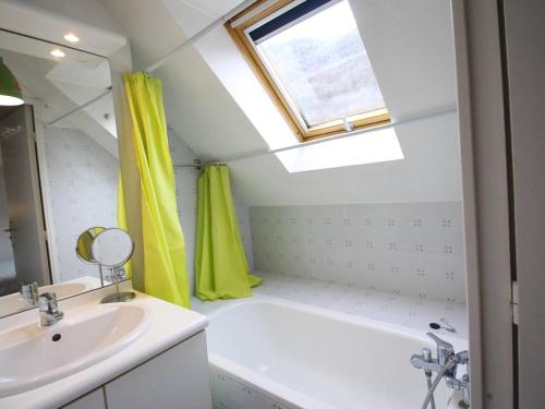 La salle de bains est pourvue d'un lavabo, d'une baignoire et d'une fenêtre. dans l'établissement Duplex centre Luchon 4 pers, balcons, parking privé - FR-1-313-239, à Luchon