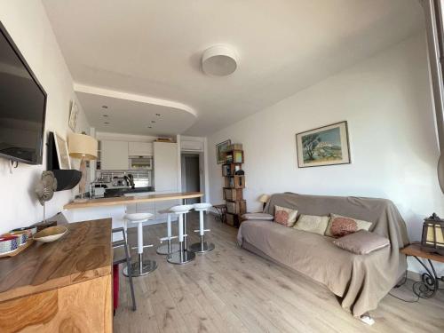 un salon avec un canapé et une cuisine dans l'établissement Appartement T2 Lumineux avec Parking Privatif - Centre-Ville - FR-1-308-203, au Lavandou