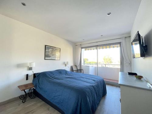 une chambre avec un lit bleu et une fenêtre dans l'établissement Appartement T2 Lumineux avec Parking Privatif - Centre-Ville - FR-1-308-203, au Lavandou