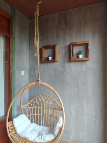 a rattan swing hanging from a wall at Little Elephant Cottage in Gili Trawangan
