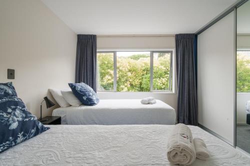 a bedroom with two beds and a window at Auckland City Escape Modern Home with Spa Pool in Auckland