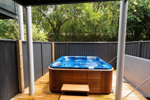 a hot tub sitting on the deck of a house at Auckland City Escape Modern Home with Spa Pool in Auckland