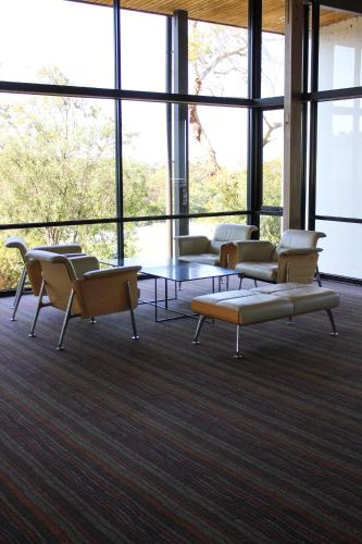 a room with chairs and a table and windows at Waurn Ponds Estate in Waurn Ponds