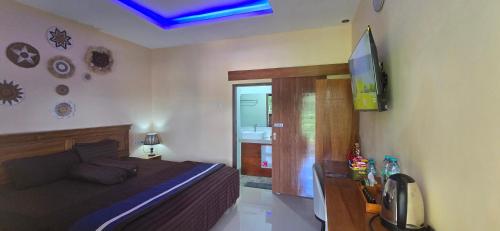 a bedroom with a bed and a flat screen tv at Holi Homestay Trawas in Trawas