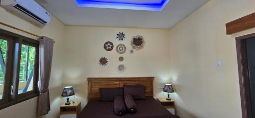 a bedroom with a bed with pillows on it at Holi Homestay Trawas in Trawas