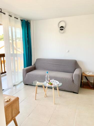 a living room with a couch and a table at Vue mer sur la Marina, Le Juliana in Pointe-à-Pitre