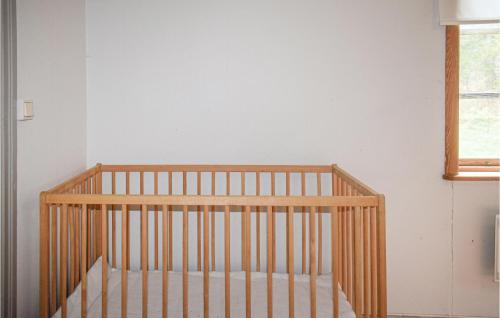 a crib in a room with a white wall at Pet Friendly Home In Ryd With Kitchen in Ryd