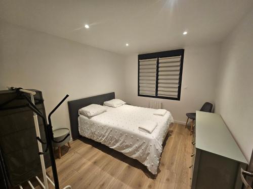 une petite chambre avec un lit et une fenêtre dans l'établissement Appartement 75m2 neuf 15 min centre ville, à Reims