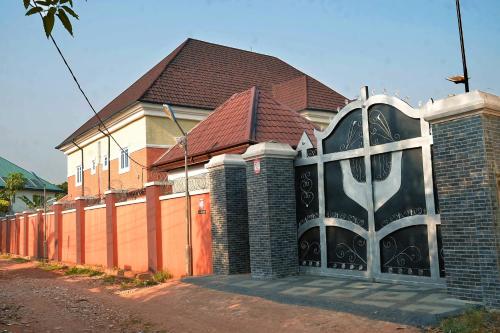 a house with a large gate in front of it at Oxford Villa in Nnewi