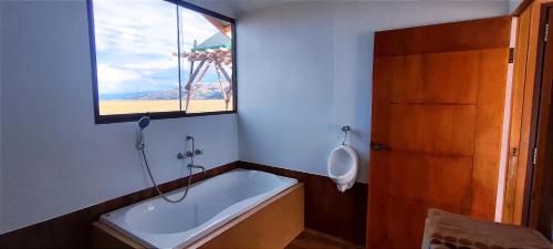 a bathroom with a bath tub and a window at Titicaca Vista Atardecer in Puno