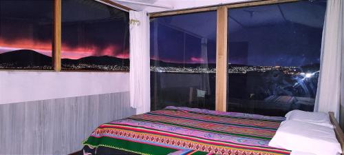 a bed in a room with a window with a view at Titicaca Vista Atardecer in Puno