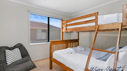 a bedroom with two bunk beds and a chair at HaltandHide by Wine Coast Holiday Rentals in Seaford