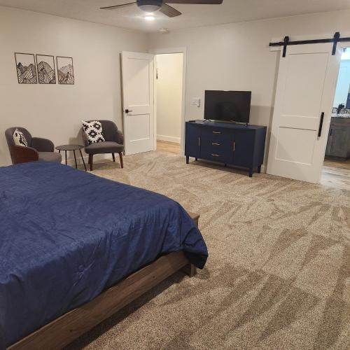 a bedroom with a bed and a flat screen tv at The Elevated Retreat in Cedar City