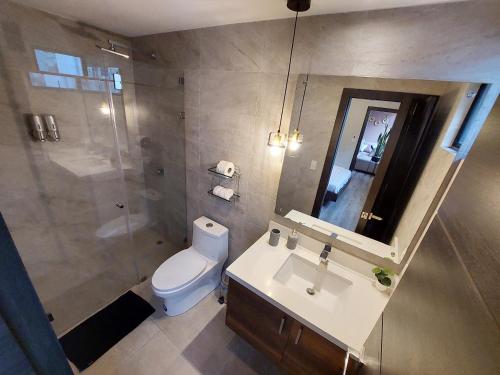 a bathroom with a toilet and a sink and a shower at Moderno departamento en el mejor sector de Quito in Quito
