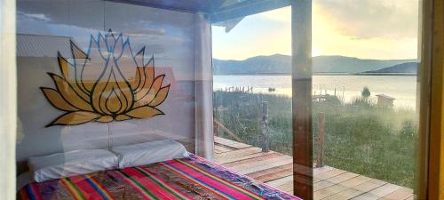 a bedroom with a large window with a view of the water at Titicaca Vista Atardecer in Puno