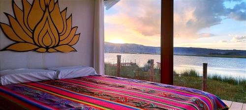 a bedroom with a window with a view of the water at Titicaca Vista Atardecer in Puno