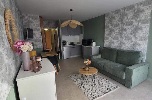 un salon avec un canapé vert et une cuisine dans l'établissement Appartement 5 couchages à Calvi, à Calvi