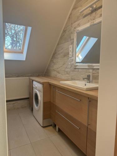 łazienka z umywalką i pralką w obiekcie Borsi Apartman w mieście Balatonalmádi