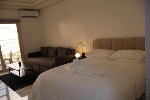 a bedroom with a large white bed and a couch at Modern Condo with Pool near Casinos in Clark in Tibo
