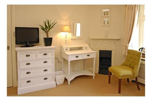 a bedroom with a desk and a tv and a desk and a chair at The Kings Arms in Sherborne