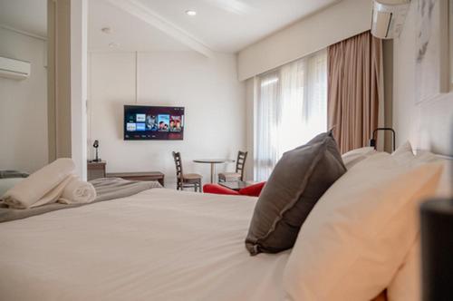 a bedroom with a large white bed with pillows on it at Mitchell On Main in Bairnsdale