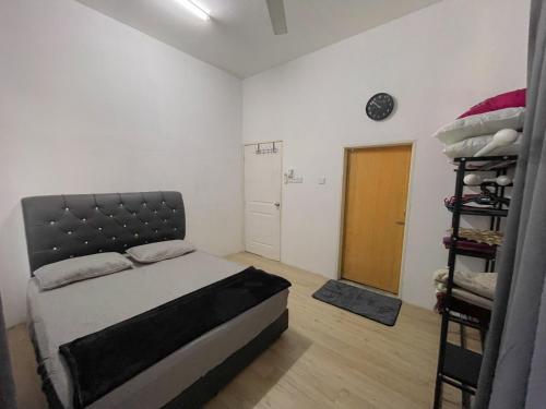 a bedroom with a bed and a shelf of clothes at Teratak Zaa D’Homestay in Kota Bharu
