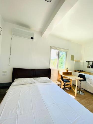 a bedroom with a large white bed and a desk at Villa Bor a Mar - Holiday homes in Puerto Galera