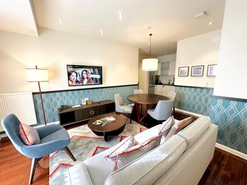 a living room with a couch and chairs and a table at Somerset City Centre Atyrau in Atyraū