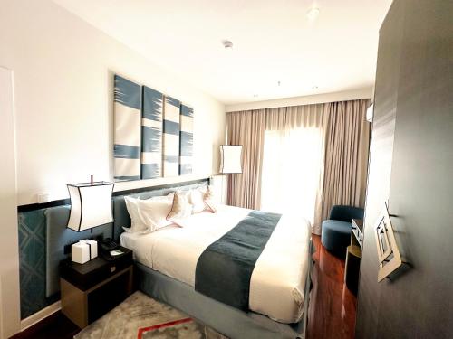 a hotel room with a bed and a window at Somerset City Centre Atyrau in Atyraū