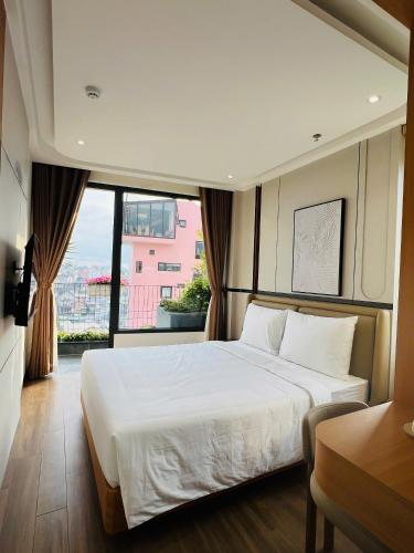 a bedroom with a large bed and a large window at Cozy Garden Boutique hotel in Khu Chi Lăng