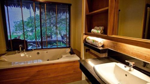 a bathroom with a tub and a sink and a window at Better View Koh Yao Yai in Ko Yao Yai