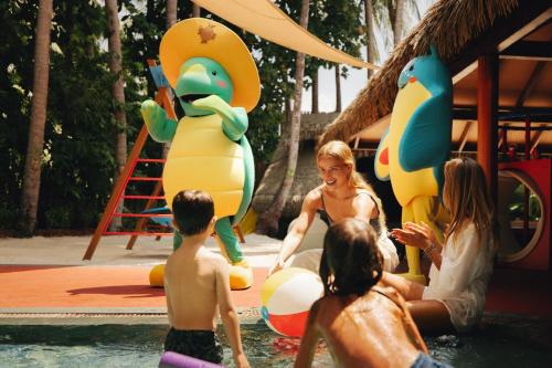 a group of children playing in the water at a water park at JOALI Maldives in Raa Atoll