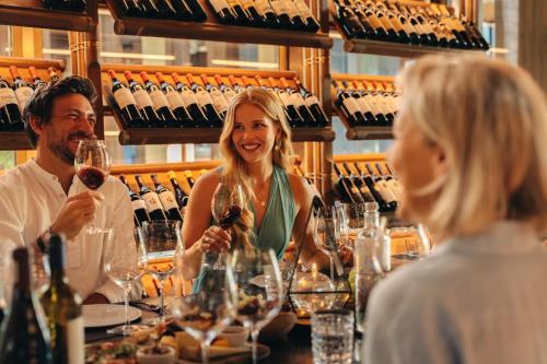 a group of people sitting at a table with wine glasses at JOALI Maldives in Raa Atoll