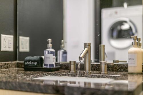 a bathroom counter with a sink and a mirror at Modern Downtown Dallas City View High-Rise, Free Parking, Pool, Gym in Dallas