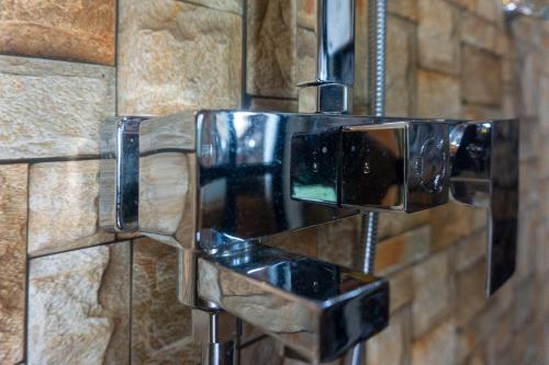 a shower in a bathroom with a faceted wall at Hobbit Hole Hideaway in Ella
