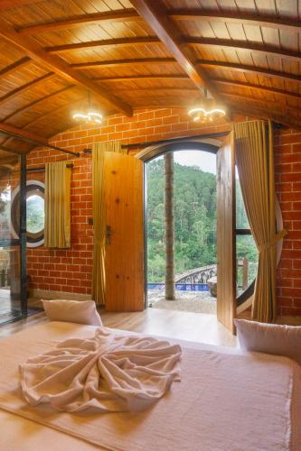 a bedroom with a large bed with a large window at Hobbit Hole Hideaway in Ella