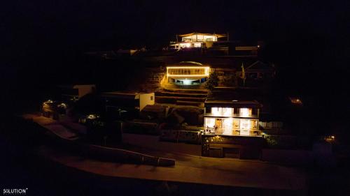 a view of a building at night with lights at La Canopée vue sur mer in Nosy Be
