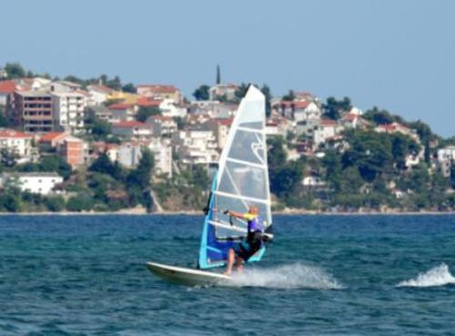 a man on a sail boat in the water at Apartmani Villa Borzic in Omiš