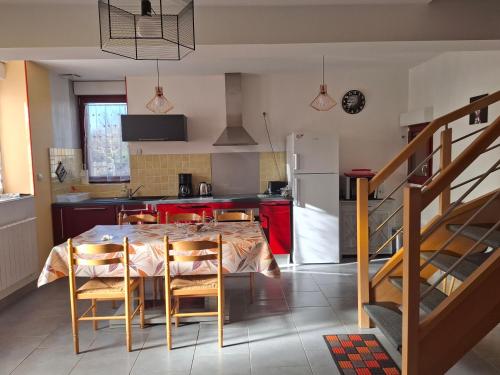 une cuisine avec une table avec des chaises et un réfrigérateur dans l'établissement Le paradis des caves, à Châteauvieux
